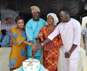 Mr Yomi Layinka being assisted by his wife Bisi and children Olufela and Niniola to cut his 60th birthday in Ibadan