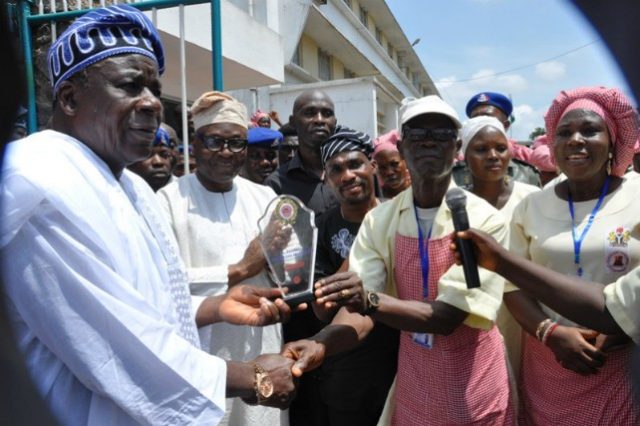 L-R: Oyo State Deputy Governor, Chief Moses Adeyemo; Secretary to the State Government, Mr. Olalekan Alli; and homegrown food vendors, during a procession to the governor's office, where the vendors presented an award to the state for the success of the programme in the state…