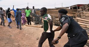 Ajimobi’s Closure Order: Plank Market Traders Protest ...a police officer here 'deals' with a plank market protester in Ibadan...