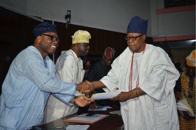 Oba Lekan Balogun, right, receives his certificate from the representative of the Government of Oyo State, Mr Olalekan Alli, the SSG...