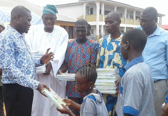 Hon Akeem Ademola Ige gives out notebooks to students during the programme...