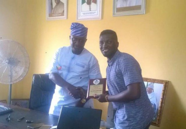 Bashorun Adekunle Oladeji, left, receives his award from a representative of the NYSC members…
