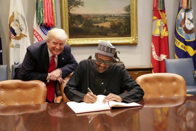 POTUS, Donald Trump, left, watches as President Muhammadu Buhari signs the visitors' register on Monday...