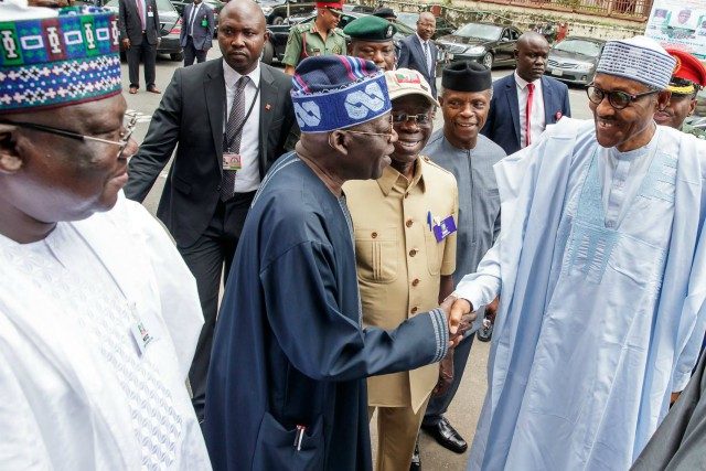 President Muhammadu Buhari, right, being welcomed to the venue of the meeting by Senator Bola Ahmed Tinubu...