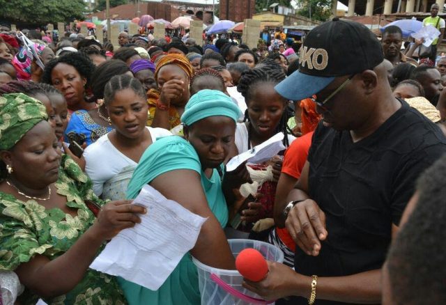 …Governor Ayodele Fayose, right, personally supervising the allocation of the shops…on Friday…