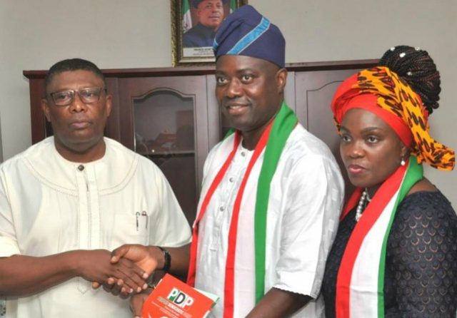 Engr Seyi Makinde (middle) submitting his ‘expression of interest form’ to the PDP National Organising Secretary, Col Austin Akobundu (rtd) while his wife, Omini looks on at the event…