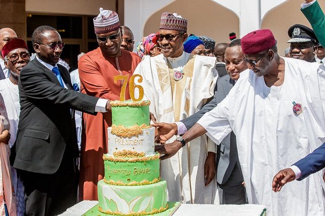 President Muhammadu Buhari...being assisted to cut his birthday cake by aides...