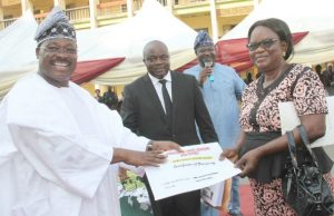Oyo Home Owners Charter: 521 C of O Ready For Collection Governor Abiola Ajimobi of Oyo State (left) presenting Certificate of Occupancy under the state Home Owners Charter to one of the beneficiaries of the scheme, Mrs..Olotu Olusoji (right). With them are the State Commissioner for Lands, Housing and Survey, Mr. Isaac Omodewu (second left) and his counterpart in the Information, Culture and Tourism ministry, Mr. Toye Arulogun (second right).