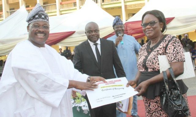 Governor Abiola Ajimobi of Oyo State (left) presenting Certificate of Occupancy under the state Home Owners Charter to one of the beneficiaries of the scheme, Mrs..Olotu Olusoji (right). With them are the State Commissioner for Lands, Housing and Survey, Mr. Isaac Omodewu (second left) and his counterpart in the Information, Culture and Tourism ministry, Mr. Toye Arulogun (second right).
