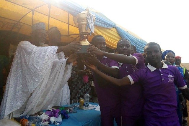 Professor Olagoke Ariyo presenting a trophy to the representatives of Purple House at the event..