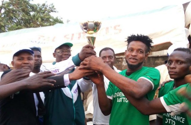 Prof. Ariyo Olagoke being assisted by Dr. Bashir Olanrewaju to present the trophy to the Captain, Shafaudeen Patriots