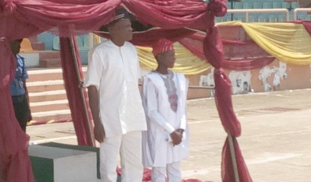 Mr. Michael Awopetu, the Hon. Commissioner for Youth and Sports in Ekiti State who represented the Ekiti State Executive Governor, Dr. Kayode Fayemi while taking salute at the 2019 Children's Day Celebrations in Ado Ekiti and Rt. Hon. Michael Adebanji, the Hon. Speaker for Ekiti State Children's Parliament standing beside the Governor's representative at Eyitayo Pavillon, New Iyin Ekiti road...
