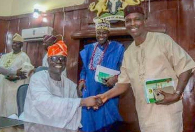 The outgoing Speaker, Hon. Olagunju Ojo in a handshake with the Chairman, Parliamentary Council, Hon. Olusegun Ajanaku. With them is Minority Leader of the House, Hon. Akeem Ige…after the Valedictory Sitting…