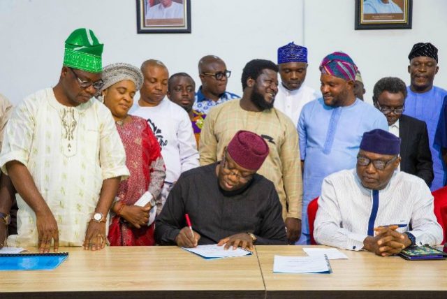 Governor Kayode Fayemi...signs...while others look on...