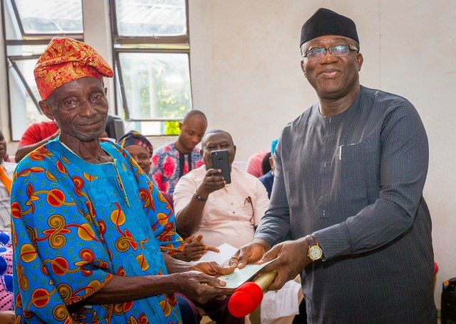 Ekiti State Governor, Dr Kayode Fayemi presenting a cheque to a retiree, Mr. Olowofela Francis…at the event…