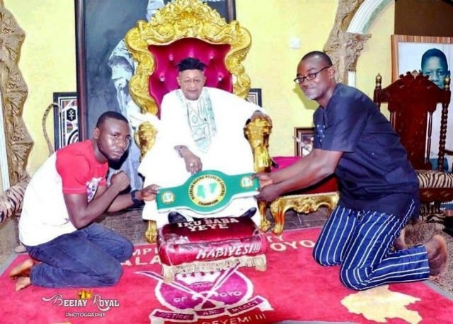 The new national title belt holder, Ridwan Scorpion Oyekola (left) presenting his belt to the Alaafin of Oyo, Oba Lamidi Olayowola Adeyemi in his Oyo palace along with his manager Sola Ford, (right)
