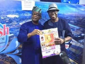 Evangelist Taiwo Omotunde right with Olayinka Agbooladisplaying one of the editions of our sister publication Parrot Xtra Magazine