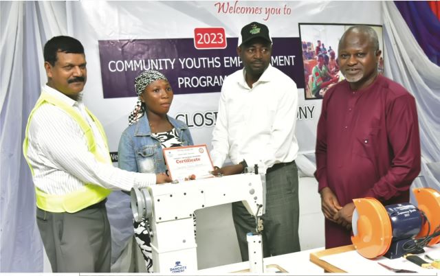 L-R, Dangote Cement Ibese, Acting Plant Director, Johnson Michael; One of the Beneficiaries receiving her certificate from the Ogun state Commissioner for Sports & Youths Development, Hon. Wasiu Adeniran Isiaka: and Dangote Cement Plc, Head of Social Performance, Wakeel Olayiwola, at the Closing ceremony of Dangote Cement Ibese Plant’s 2023 Skill Acquisition and Empowerment Program held at the Dangote Cement Ibese plant Ogun State…