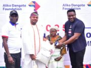 L-R: Head Social Performance, Dangote Cement Plc, Ibese Plant Ademola Ojolowo; HIs Royal Majesty Oba Rotimi Oluseyi Mulero, Aboro of Ibaseland; Banis Bankole, One of the Beneficiaries and representative of Aliko Dangote Foundation, Edero Victor Ejiro; during the distribution of 10KG Bags Of Rice in Ibese…