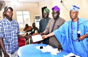 Students In Ijebu Igbo Benefit From Dangote Granite Mines’ Bursary Awards L-R: Shoneye Damilola, a student beneficiary from Beje High school, receiving the bursary Cheque; General Manager, Community Relations, Dangote Granite Mines Ltd, Pastor Joseph Alabi; Dangote Granite Mines Ltd, General Manager, Projects Control, Samuel K. Fagbile and High Chief Ademola Ogunyale, a representatives of His Royal Highness…