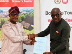 Makinde’s Govt Reveals Plans To Redevelop Historic Bower’s Tower Two men shake hands while exchanging a blue document at a corporate event, with Bower's Tower banners in the background.