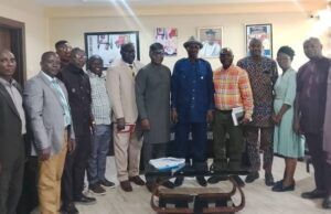 Oyo Govt, FERMA Strengthen Collaboration On Road Maintenance Group of professionals posing for a photo in a conference room, some holding folders, a glass coffee table in front.