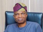 Oyo Govt. Launches Free Evening Market Classes To Tackle Out-Of-School Menace Man wearing a purple‑green headwrap and blue traditional outfit, seated in a dark leather chair.