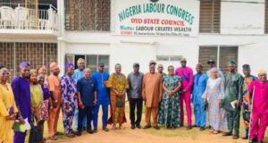 WORKERS’ DAY: Oyo Pays 18bn Salaries Monthly, As NLC Chairman Confirms State’s 4th Position in Workers’ Welfare Group of men and women in colorful attire posing in front of a Nigeria Labour Congress, Oyo State Council banner on a building wall.