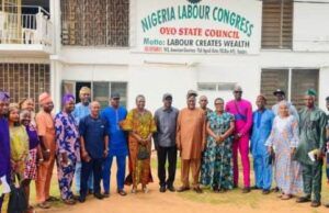 WORKERS’ DAY: Oyo Pays 18bn Salaries Monthly, As NLC Chairman Confirms State’s 4th Position in Workers’ Welfare Group of men and women in colorful attire posing in front of a Nigeria Labour Congress, Oyo State Council banner on a building wall.