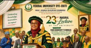 How Ekiti SSG, Prof. Mrs. Adubiaro Disappointed Me At Her Inaugural Lecture Female professor in green and gold ceremonial robes speaks at a podium during the 23rd Inaugural Lecture at Federal University Oye-Ekiti, with a university seal and banners in the background.