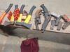 Oyo Police Foil Cult Attack At Ibadan Poly Assorted hand tools laid out on a wooden workbench, including axes, hammers, pliers, and wrenches, with a red cloth on the ground nearby.