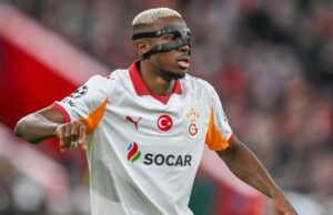 Galatasaray’s Victory Over Fenerbahçe Thrills Osimhen Soccer player in a white Galatasaray jersey with SOCAR sponsor, wearing a protective face mask during a match.
