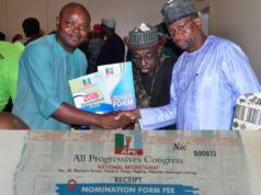 Battle For APC Gubernatorial Ticket: Barr Akeem Agbaje Picks Forms Three men shake hands at a political event, presenting a nomination form while a large APC receipt sits in the foreground.