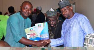 Battle For APC Gubernatorial Ticket: Barr Akeem Agbaje Picks Forms Three men shake hands at a political event, presenting a nomination form while a large APC receipt sits in the foreground.