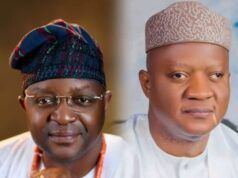 Akeem Agbaje Joins Others To Salute As Sunday Dare Turns 60 Two men in traditional Nigerian attire sit side by side; left wears glasses and a colorful patterned cap, right wears a light patterned cap and white robe.