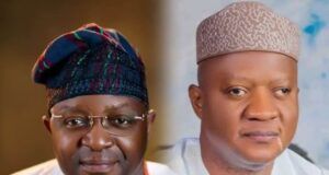 Akeem Agbaje Joins Others To Salute As Sunday Dare Turns 60 Two men in traditional Nigerian attire sit side by side; left wears glasses and a colorful patterned cap, right wears a light patterned cap and white robe.