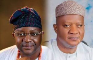 Akeem Agbaje Joins Others To Salute As Sunday Dare Turns 60 Two men in traditional Nigerian attire sit side by side; left wears glasses and a colorful patterned cap, right wears a light patterned cap and white robe.