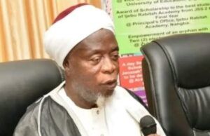 Ijebuland Needs New Awujale Before Sallah, Ijebu Chief Imam Begs Abiodun Religious leader wearing a white turban and robe speaks into a handheld microphone at a conference table.