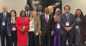Nigeria Showcases Gains Of Education Reforms At Global Forum Group of diverse professionals wearing conference badges posing for a group photo at a formal event venue.