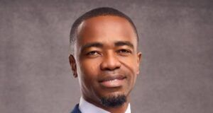 First Bank Strengthens Leadership As Julius Omodayo-Owotuga Joins Board As Executive Director Professional portrait of a man in a blue pinstripe suit, white shirt, and patterned tie, looking at the camera with a calm smile.