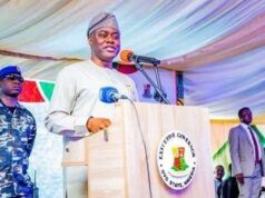Makinde Declares Presidential Ambition Ahead Of 2027 Elections Governor in traditional attire speaking at a podium with the Oyo State seal, flanked by security personnel at an outdoor event.