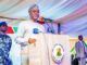 Court Stops EFCC From ‘Speculative Investigation’ Of Oyo Finances Governor in traditional attire speaking at a podium with the Oyo State seal, flanked by security personnel at an outdoor event.