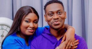 Nollywood Actor Lateef Adedimeji, Wife Welcome Triplet Sons Smiling couple hugging; woman in blue rests her arms on the man’s shoulders, both facing the camera.