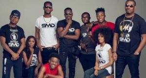 Don Jazzy Explains Origin Of Hit Song ‘Dorobucci’ Group of people posing together in a photography studio, many wearing branded SMD shirts and sunglasses.