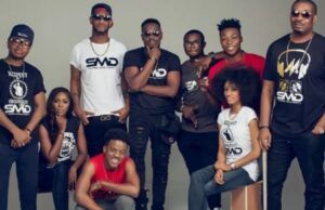 Don Jazzy Explains Origin Of Hit Song ‘Dorobucci’ Group of people posing together in a photography studio, many wearing branded SMD shirts and sunglasses.