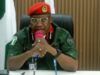Oyo NSCDC Agro Rangers Neutralise 1 Suspected Criminal; Arrest Two Others In Iseyin Military officer in a green uniform and red beret speaking into a pink microphone at a desk in a conference room, with flags in the background.
