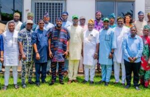 Ogundoyin Leads Oyo Lawmakers To Endorse Bimbo Adekanmbi As APM Governorship Aspirant Group of diverse adults standing on a lawn in front of a building, wearing colorful traditional attire and smiling.