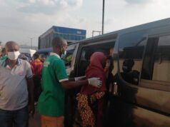 Makinde’s Govt, Security Agencies Clear Ibadan Streets of Destitutes, Beggars A man in a green shirt helps a woman in a red headscarf board a dark bus/van as others wear masks nearby in a busy transport scene.