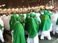 945 Oyo Hajj Pilgrims Arrive In Makkah, As Final Batch Departs for Medina Group of pilgrims in white garments with green shawls walking together at night during a religious procession.