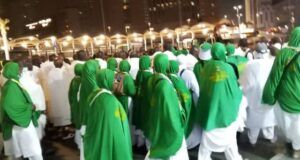 945 Oyo Hajj Pilgrims Arrive In Makkah, As Final Batch Departs for Medina Group of pilgrims in white garments with green shawls walking together at night during a religious procession.